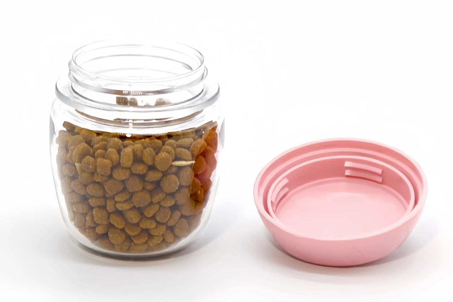 Contenedor transparente con croquetas para perro y tapa rosada desmontable, parte superior del sistema de botella portátil Petify™, ideal para transportar snacks de forma segura e higiénica.